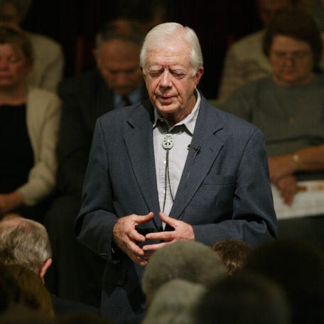 Former President Jimmy Carter leads the congregation in prayer after teaching Sunday School at Maranatha Baptist Church in Plains, Ga. on Sept. 29, 2002.