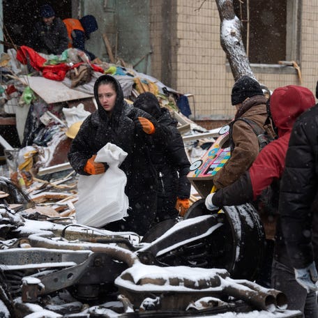 Survivors of a Russian missile attack in Kyiv, Ukraine, gather belongings amid the debris of their destroyed home on Jan. 3, 2024.