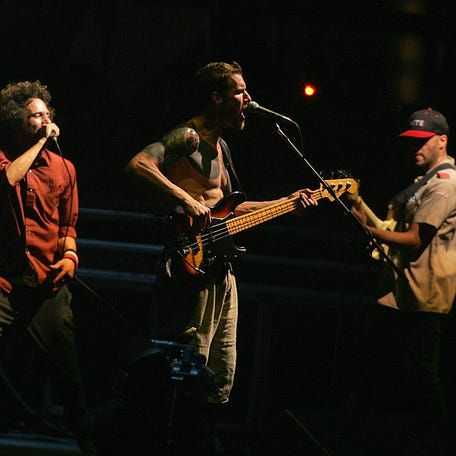Together again from left Zack de la Rocha, Tim Commerford, center, and Tom Morello of Rage Against The Machine perform at the Coachella Valley Music and Arts Festival in Indio, Calif., on Sunday, April 29, 2007. (AP Photo/Branimir Kvartuc) ORG XMIT: CABK122