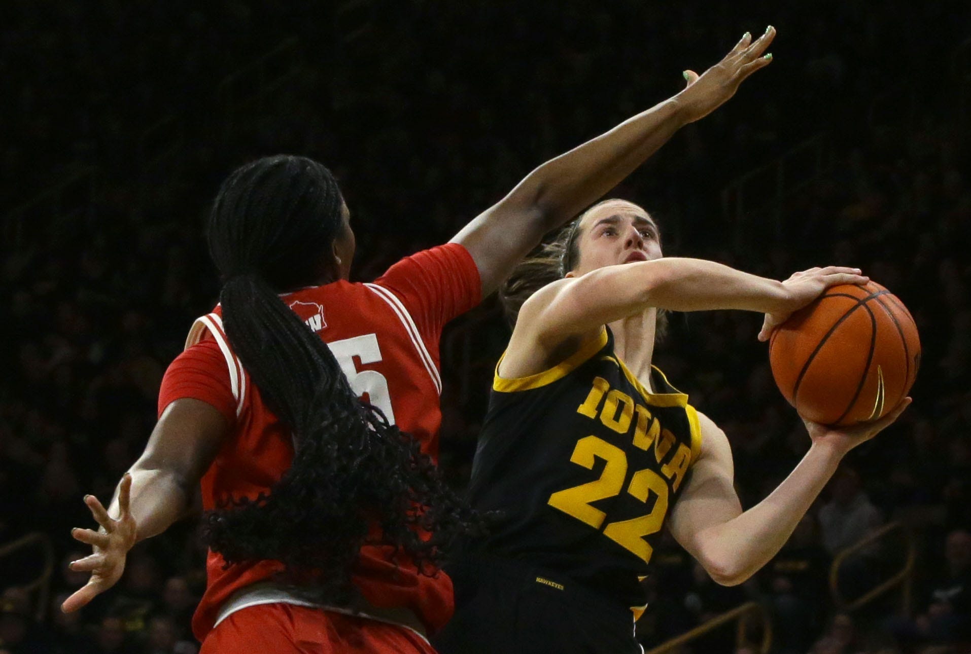 Caitlin Clark (22) shoots while defended by Wisconsin's Serah Williams.
