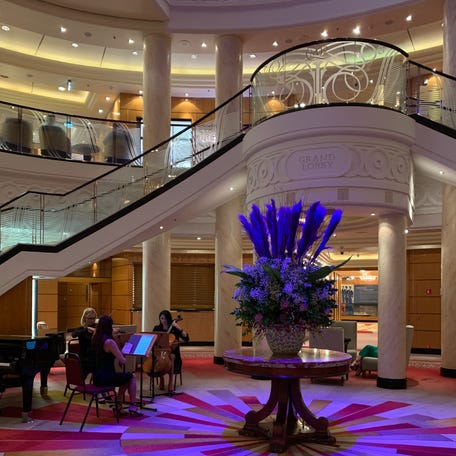 The Grand Lobby on board the Queen Mary 2 in January of 2024 during the crossing from New York to Southampton, UK., as a string trio plays.