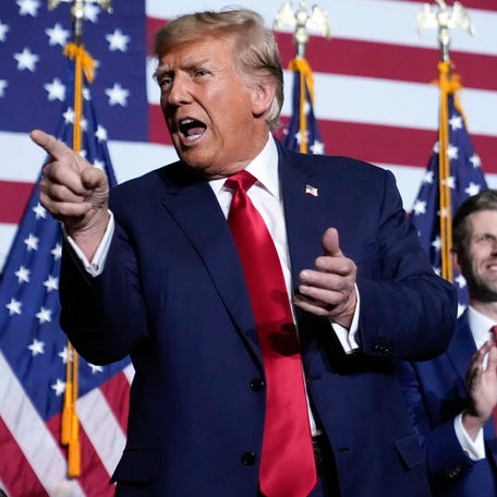 Republican presidential candidate Donald Trump points to the crowd, accompanied by his son, Eric, at a caucus night party in Des Moines, Iowa, Monday, Jan. 15, 2024. (AP Photo/Andrew Harnik) ORG XMIT: PNA310