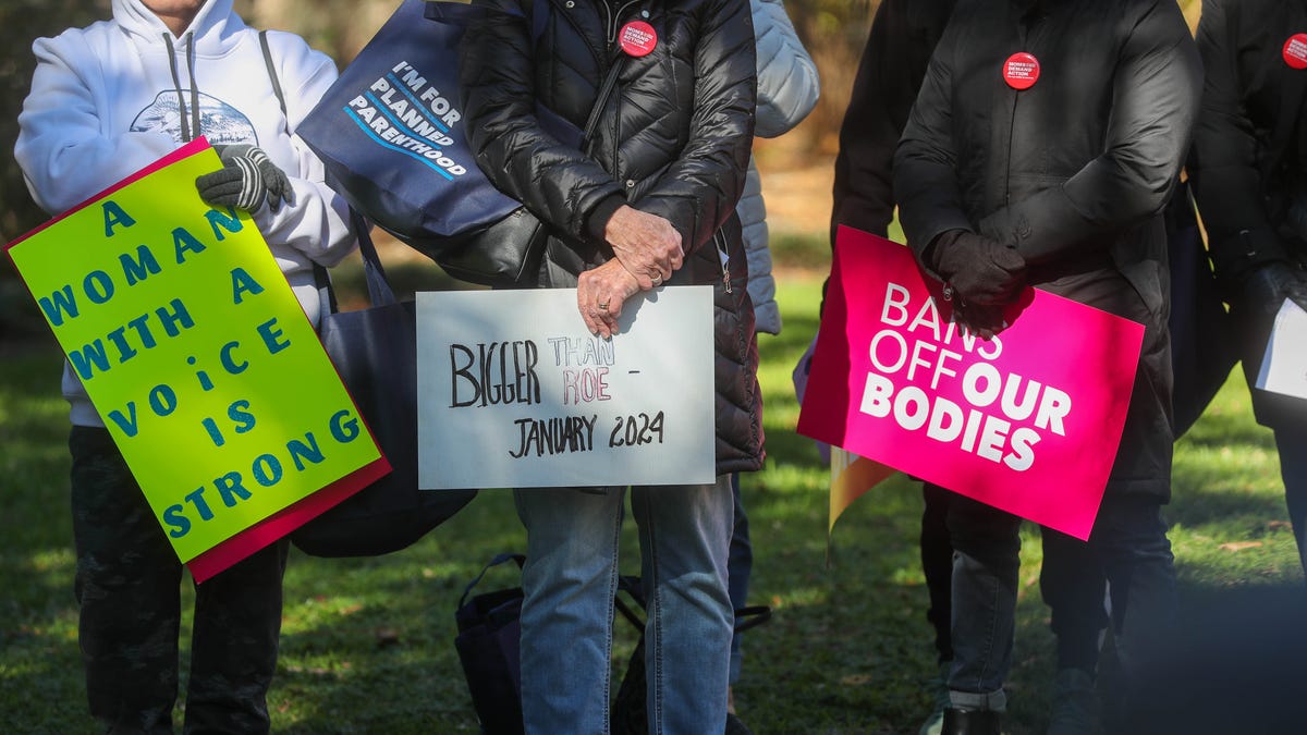 A group of abortion-rights supporters hold signs during the "Bigger Than Roe" rally and march on Saturday, January 20, 2024 at Forsyth Park.