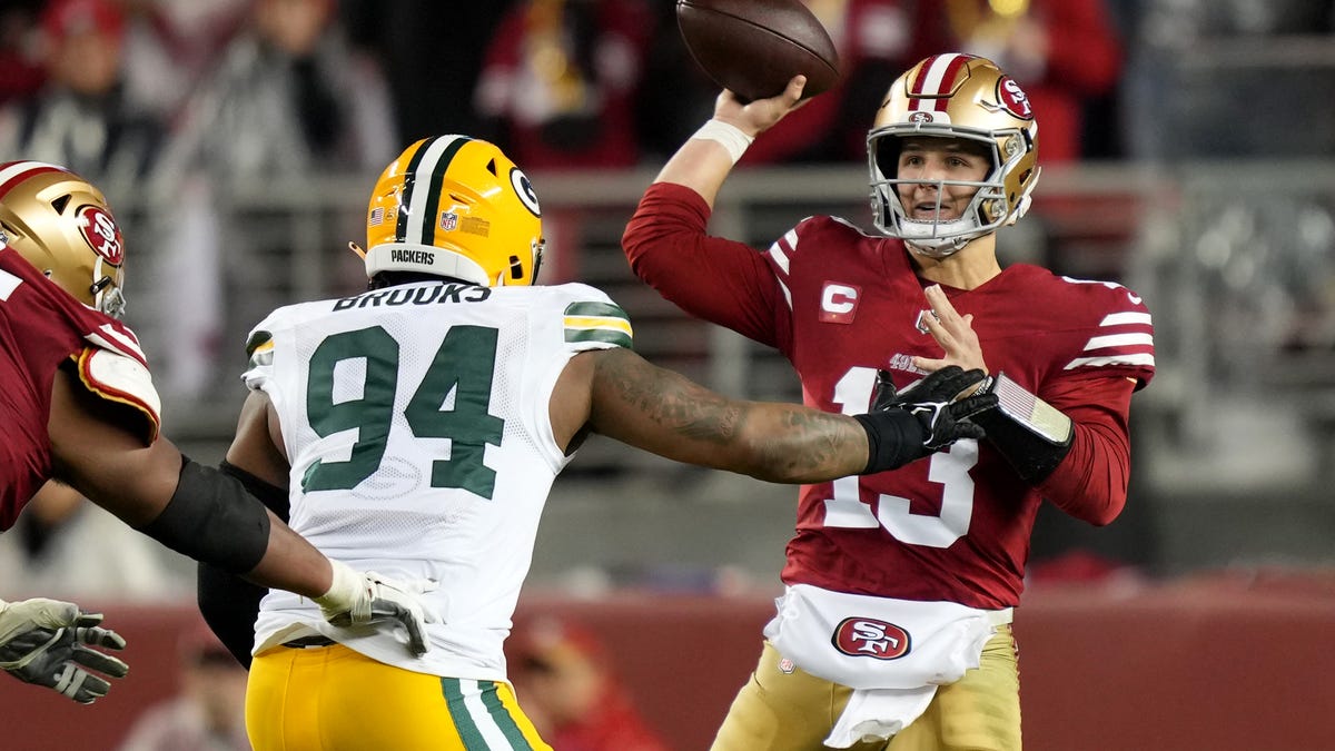 San Francisco 49ers quarterback Brock Purdy (13) passes under pressure from Green Bay Packers defensive end Karl Brooks (94) during the third quarter.