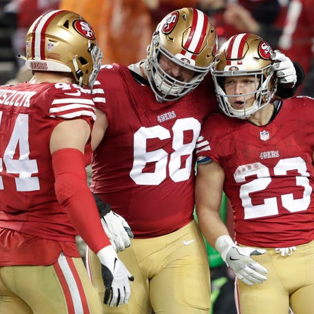 San Francisco 49ers running back Christian McCaffrey (23) celebrates scoring a touchdown in the third quarter with fullback Kyle Juszczyk (44) and offensive tackle Colton McKivitz (68) against the Green Bay Packers in a 2024 NFC divisional round game at Levi's Stadium.