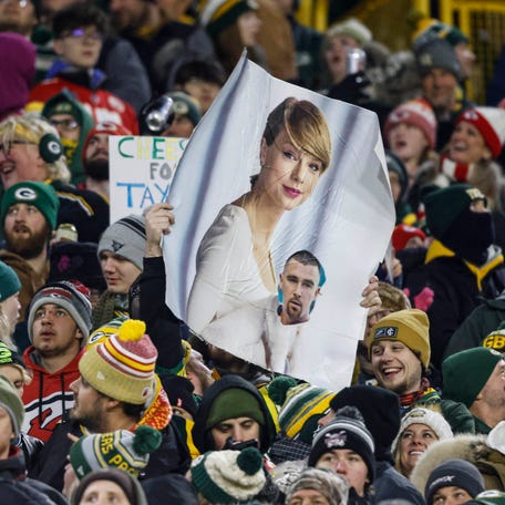 A fan holds a sign of Taylor Swift and Travis Kielce in Green Bay on Dec. 3.