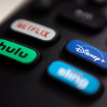 Logos for Netflix, Hulu, Disney Plus and Sling TV are pictured on a remote control.