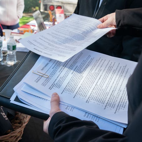 Nathaniel Pagendarm, 24 hands his resume to Peter Chekijan (L) of Twin Fork Beer Co. at the Employers Only Long Island Food, Beverage and Hospitality Job Fair on October 19, 2021 in Melville, New York.