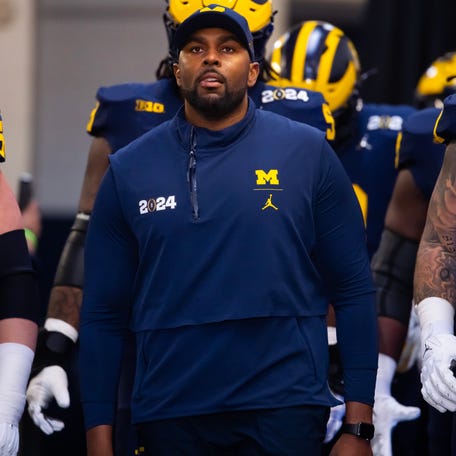 Michigan offensive coordinator Sherrone Moore walks to the field ahead of the College Football Playoff national championship game against Washington at NRG Stadium.