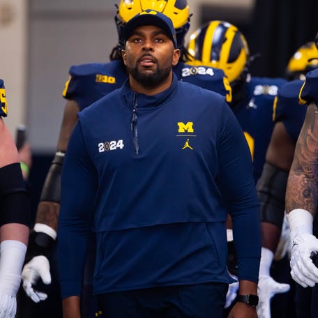Michigan offensive coordinator Sherrone Moore walks to the field ahead of the College Football Playoff national championship game at NRG Stadium.