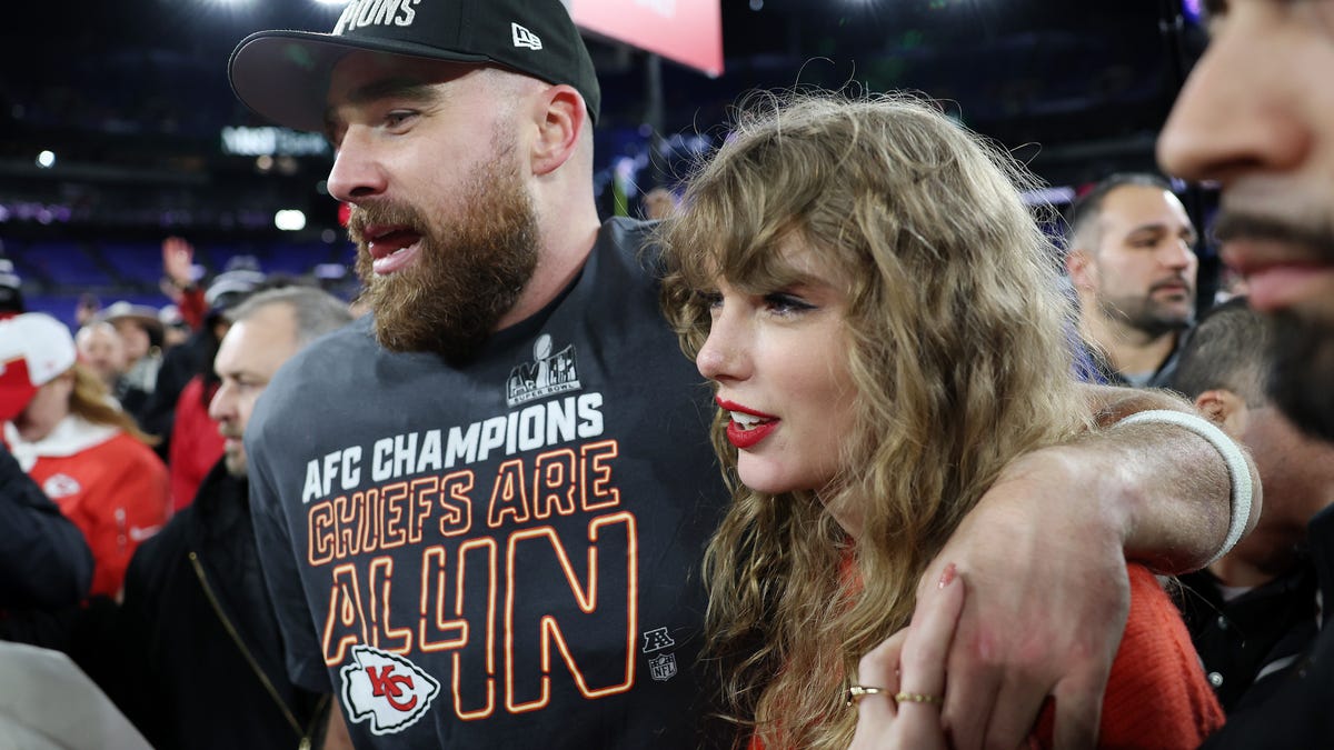 Travis Kelce celebrates with Taylor Swift on the field after a 17-10 victory against the Baltimore Ravens in the AFC Championship Game at M&T Bank Stadium on January 28, 2024.