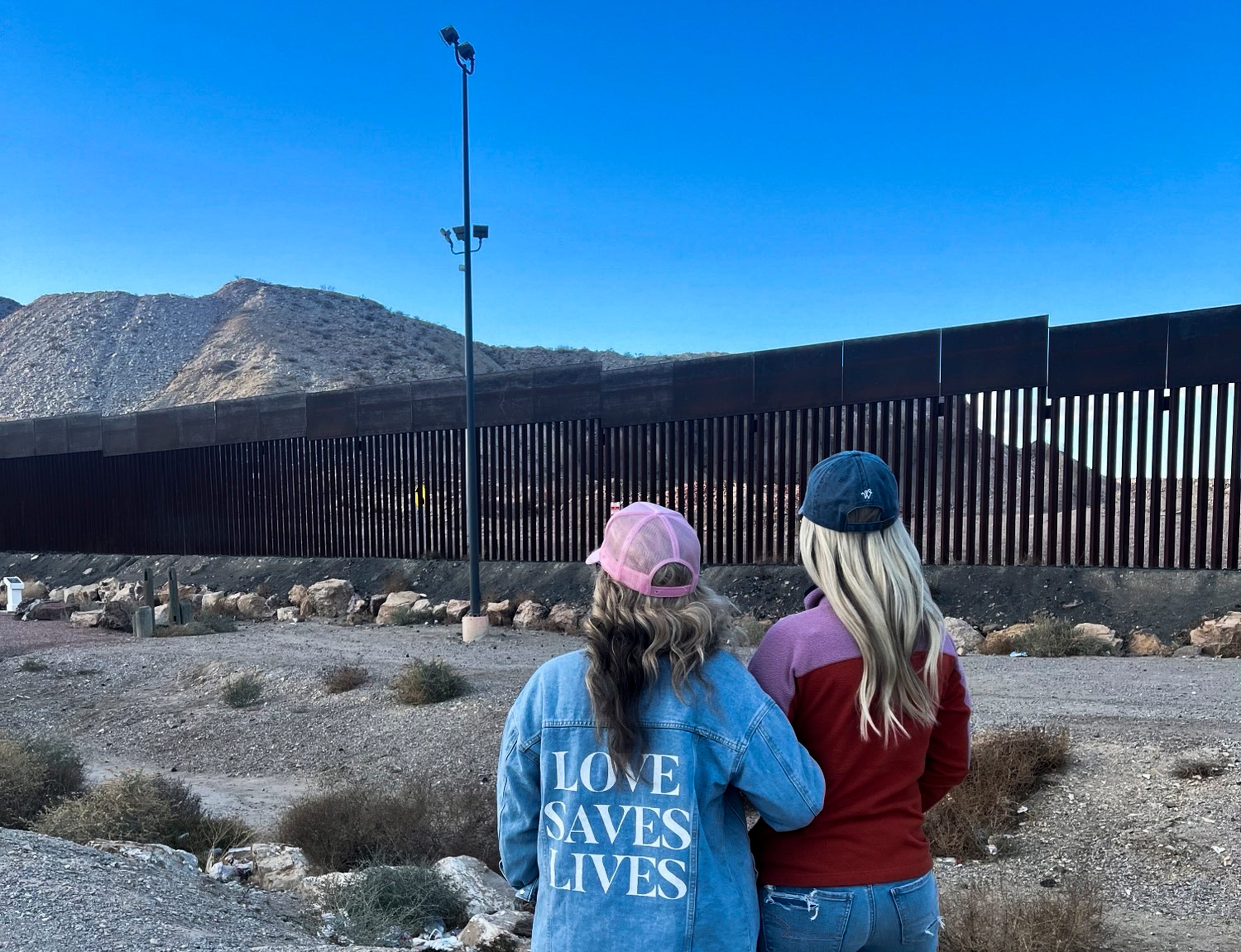 Amy Ford, co-founder of the anti-abortion group Embrace Grace, left, and Bri Stensrud, Director of Women of Faith, look at the border wall.