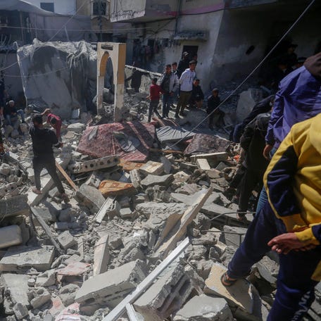 People search for victims in the rubble of the Baraka family home in Deir al-Balah in the central Gaza Strip after it was hit in an Israeli air strike on Sunday, February 18, 2024, amid ongoing battles between Israel and the Palestinian militant group Hamas in the besieged Palestinian territory.