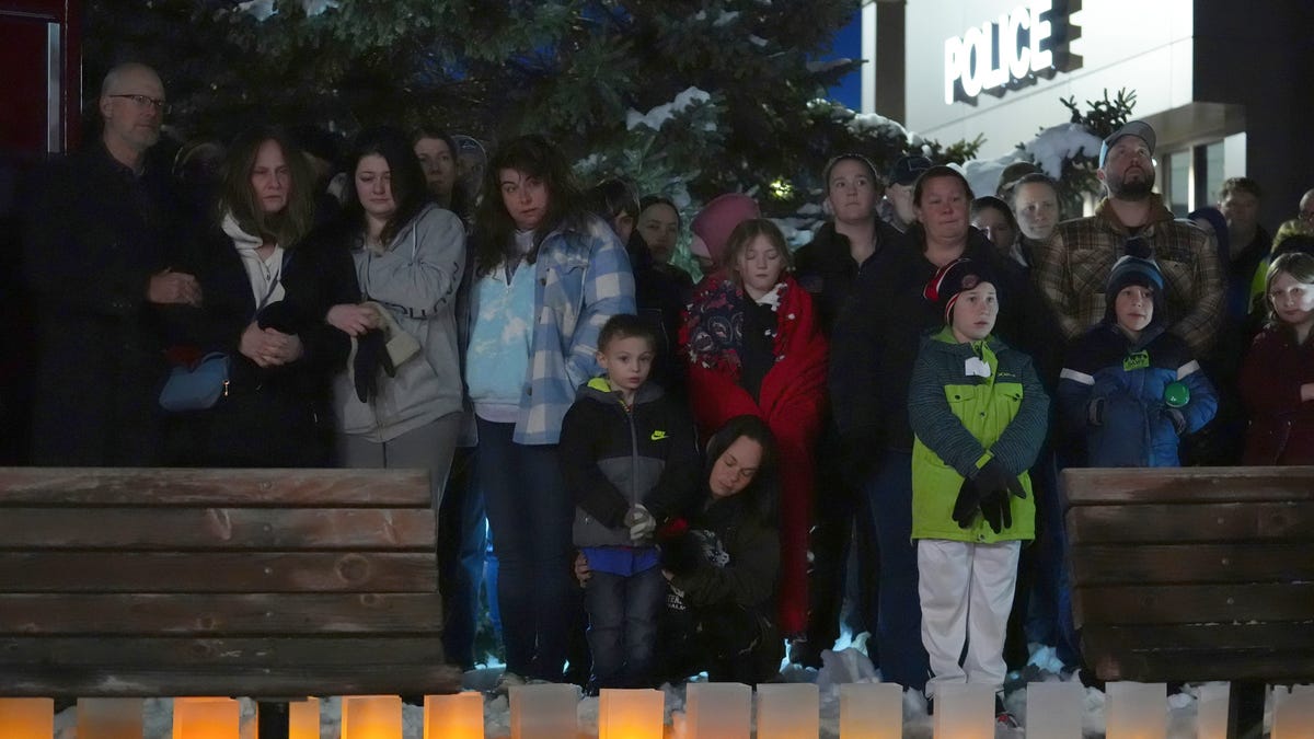 People attend a candlelight vigil after two police officers and a first responder were shot and killed Sunday, Feb. 18, 2024, in Burnsville, Minn.