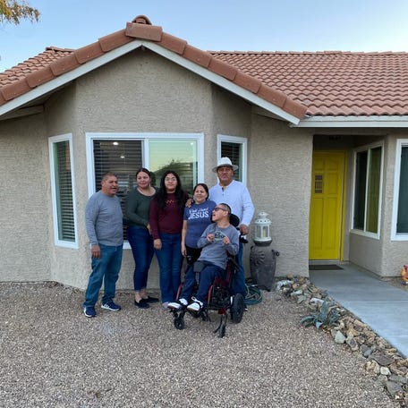 Juan Carlos López Flores (in hat) and his wife, Maria Chavarría, bought their first house in Las Vegas. He and his brother's family will live in the house together.
