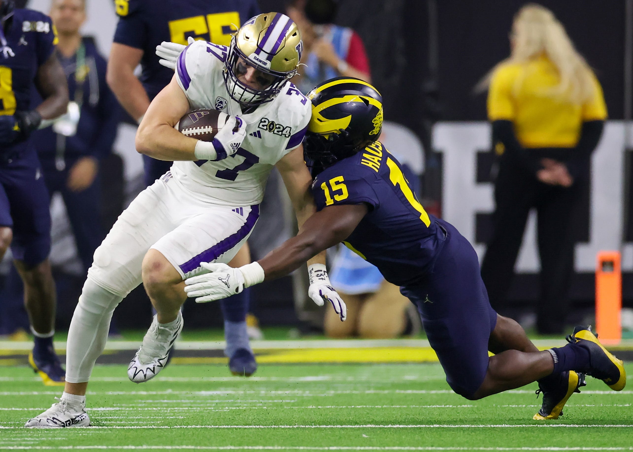 Washington tight end Jack Westover (37) is tackled by Michigan linebacker Ernest Hausmann (15) during the College Football Playoff national championship game at NRG Stadium.