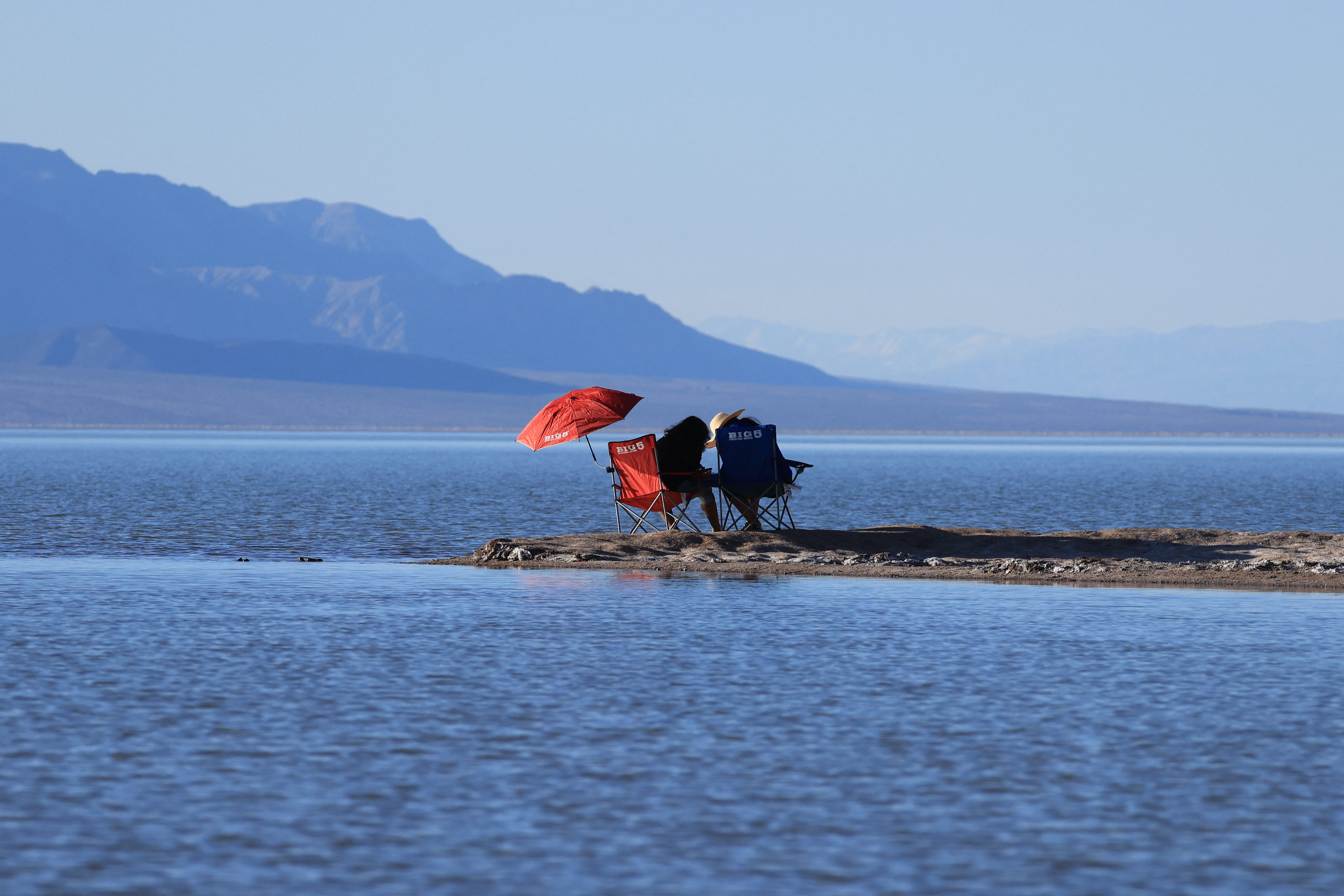 People relax by the water's edge as they enjoy the rare opportunity to see water during their visit to Badwater Basin, the normally driest place in the US, in Death Valley National Park, Inyo County, California on February 18. Badwater Basin, an endorheic basin in Death Valley National Park, was flooded by Hurricane Hilary in August 2023 and recent rains in California. It is the lowest point in North America, at 282 feet (86 meters) below sea level.