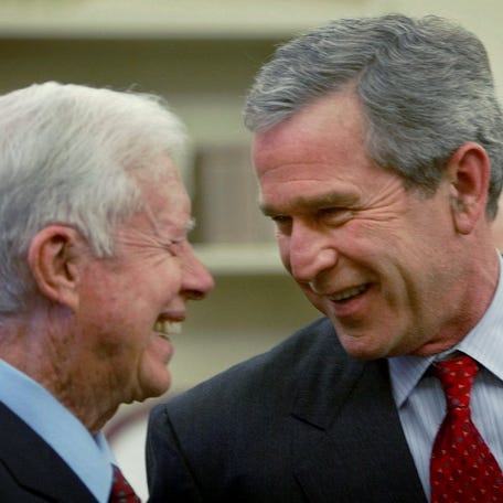 President Bush, right, smiles as he greets former President Jimmy Carter, left, during a reception for U.S. 2002 Nobel laureates in the Oval Office of the White House, Monday, Nov. 18, 2002 in Washington. (AP Photo/Pablo Martinez Monsivais) ORG XMIT: PMM101