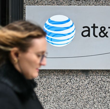 A woman walks past signage for AT&T in Washington, DC, on February 22, 2024.