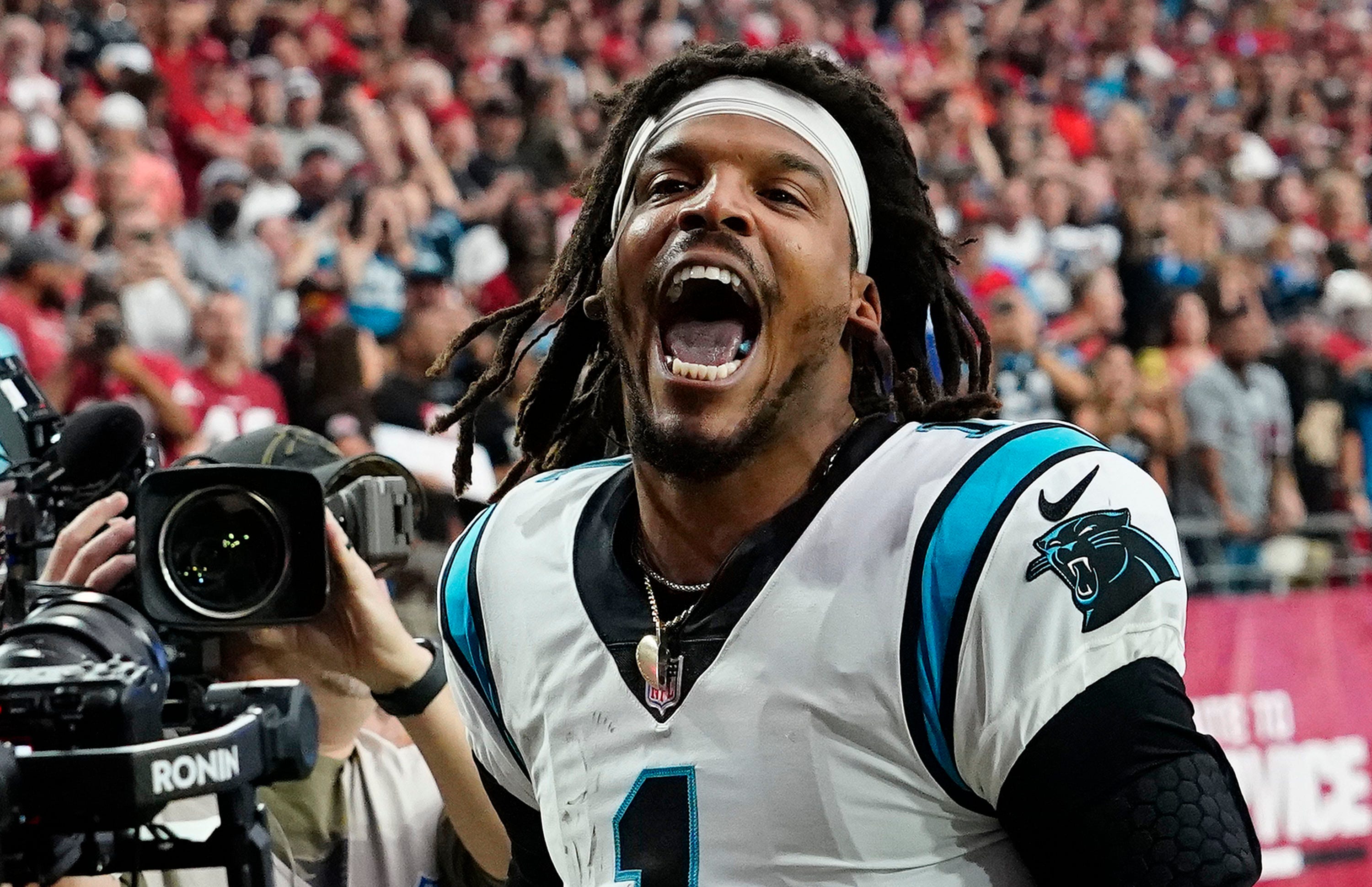 Carolina Panthers quarterback Cam Newton yells "I'm back!" after scoring a rushing touchdown against the Arizona Cardinals in a game in 2021.