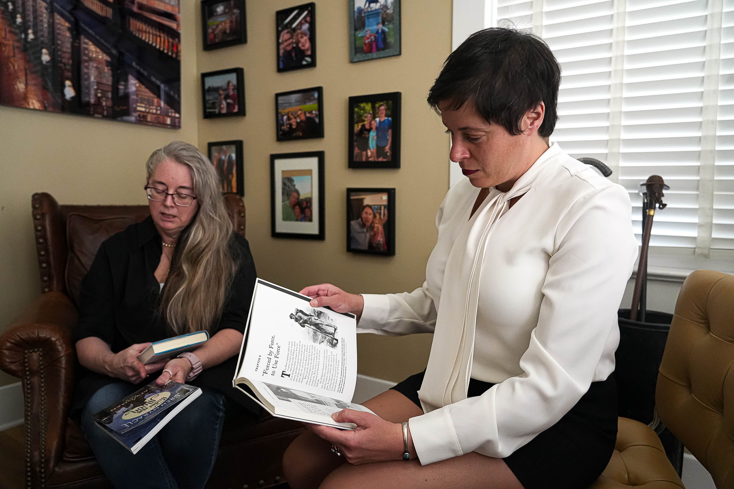Iris Halpern, partner at Rathod Mohamedbhai LLC, right, looks through one of the books that was removed from the Kingsland Branch library in Llano county where her client Suzette Baker, left, was the head librarian before being terminated in 2022.