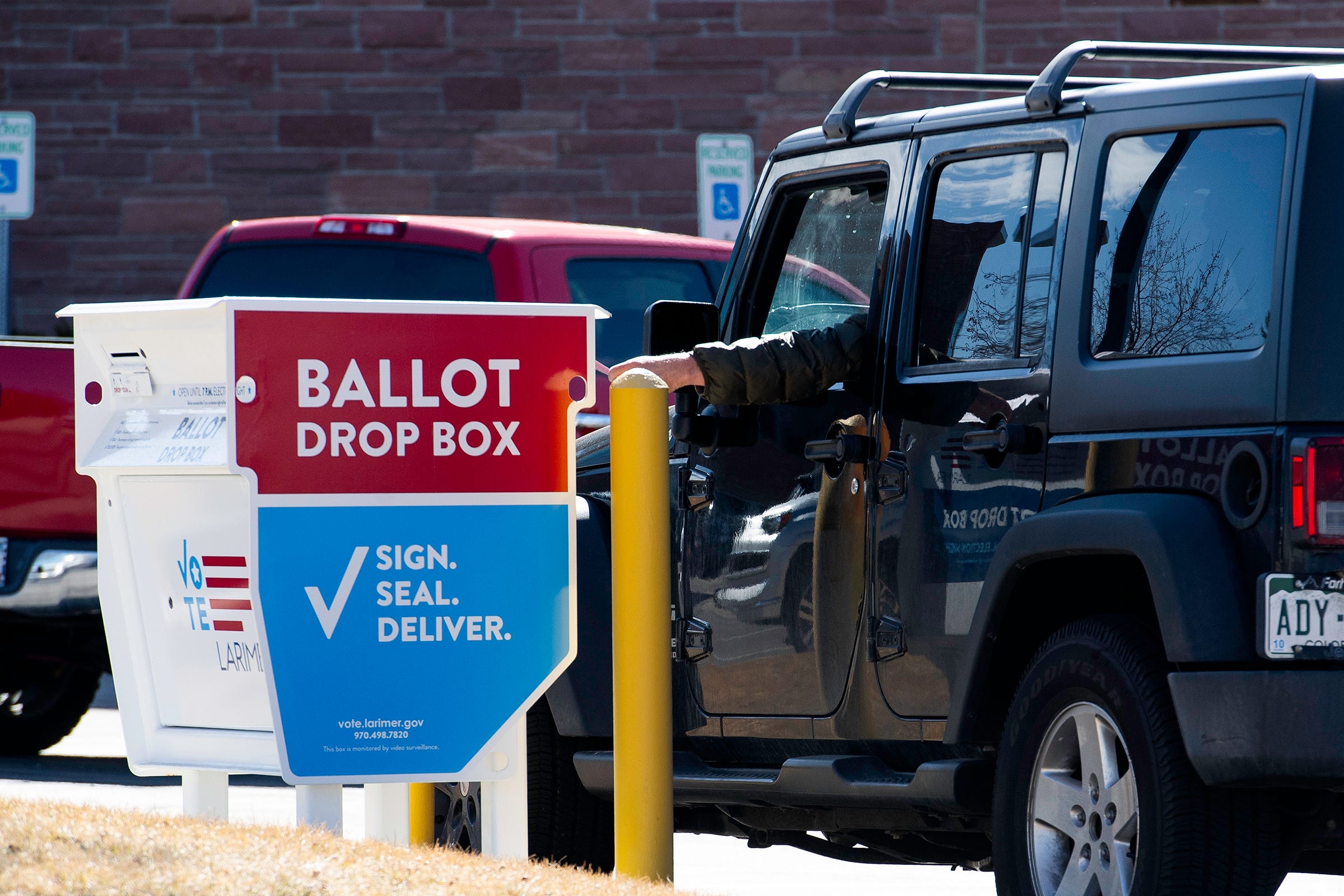 A person uses a ballot drop box during Super Tuesday in Fort Collins, Colo., on Tuesday, March 5, 2024.