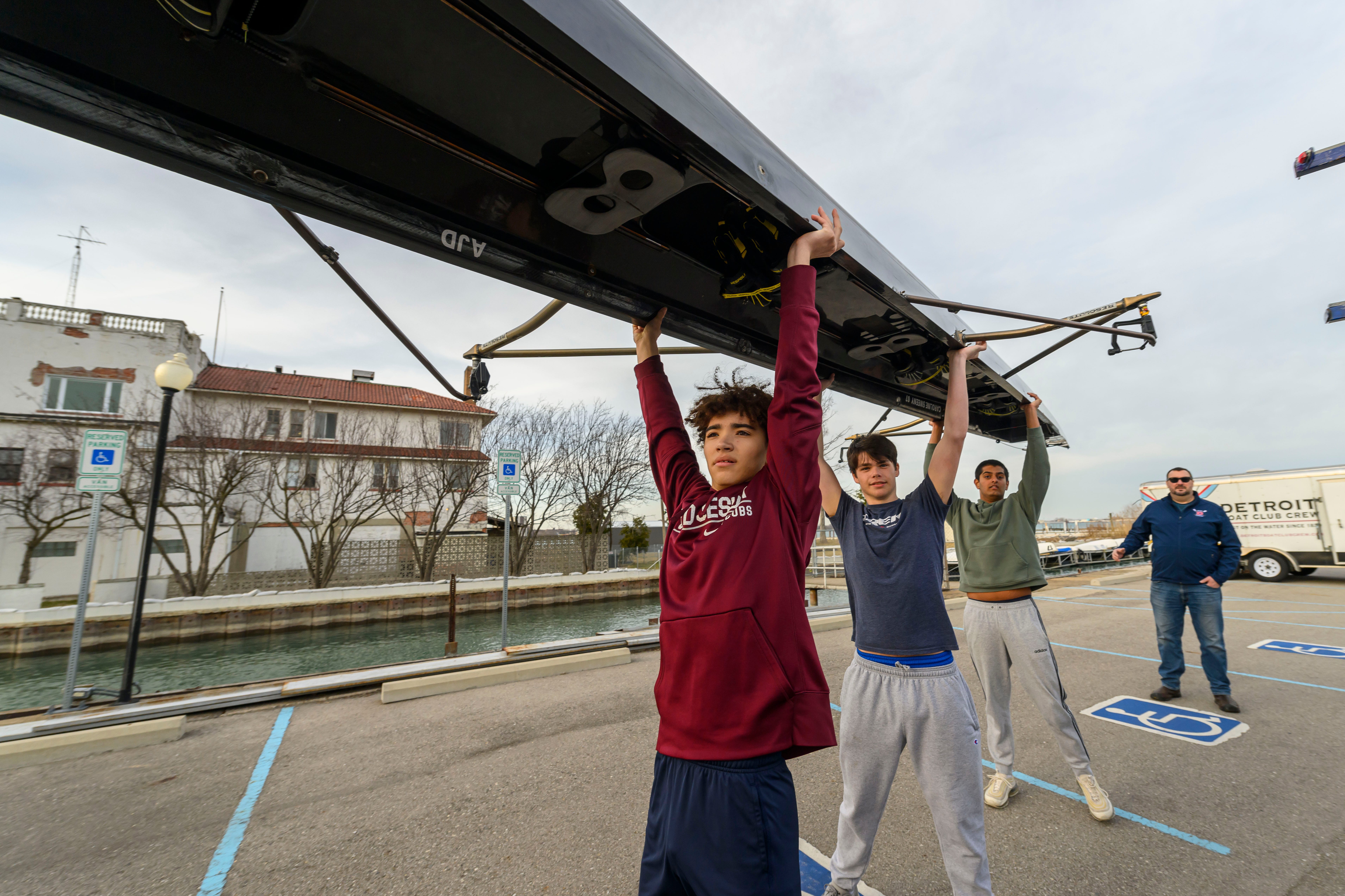 The Detroit Boat Club Crew members load a shell onto a trailer on Belle Isle, March 12, 2024. The Michigan Department of Natural Resources approved a plan in October for the club to erect a temporary tent in the boathouse's parking lot for practice and the storage of a dozen shells and sculls.