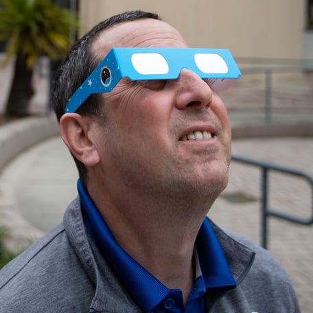 Alan Hanstein, executive director of the Challenger Learning Center, uses solar eclipse glasses to look directly at the sun Wednesday, March 13, 2024.
