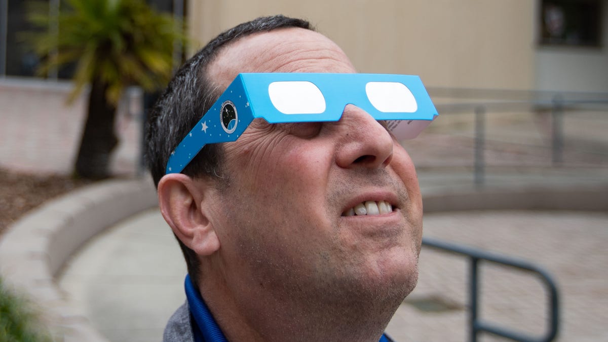 Alan Hanstein, executive director of the Challenger Learning Center, uses solar eclipse glasses to look directly at the sun Wednesday, March 13, 2024.