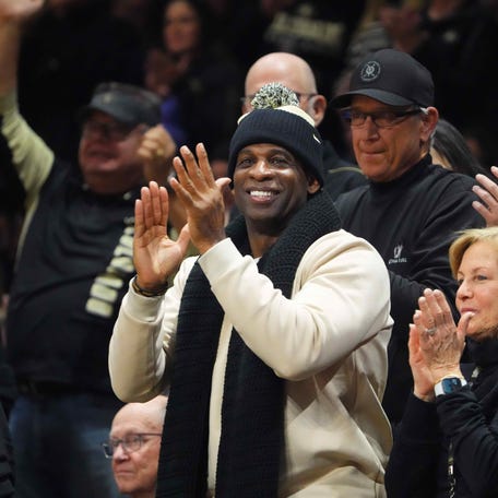 Colorado Buffaloes football coach Deion Sanders cheers at a game against the USC Trojans at the CU Events Center.