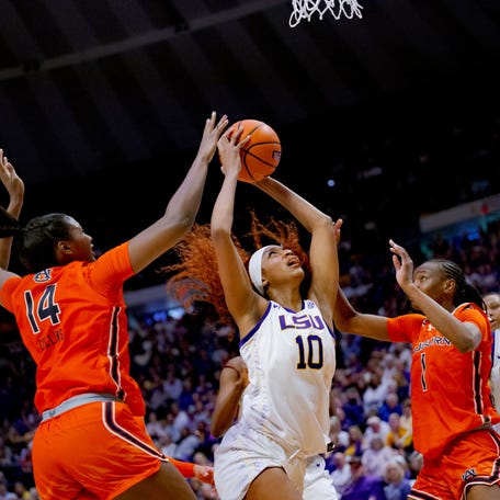 Auburn forward Taylen Collins (14) and forward Celia Sumbane (1) defend LSU's Angel Reese during the second half of their game at Pete Maravich Assembly Center in Baton Rouge, Louisiana on Feb. 22, 2024.