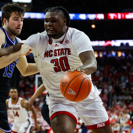 North Carolina State forward DJ Burns Jr. (30) dribbles the ball while being guarded by Duke center Ryan Young (15) during the first half at PNC Arena.