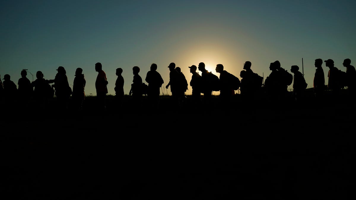 FILE - Migrants who crossed the Rio Grande and entered the U.S. from Mexico are lined up for processing by U.S. Customs and Border Protection, Sept. 23, 2023.