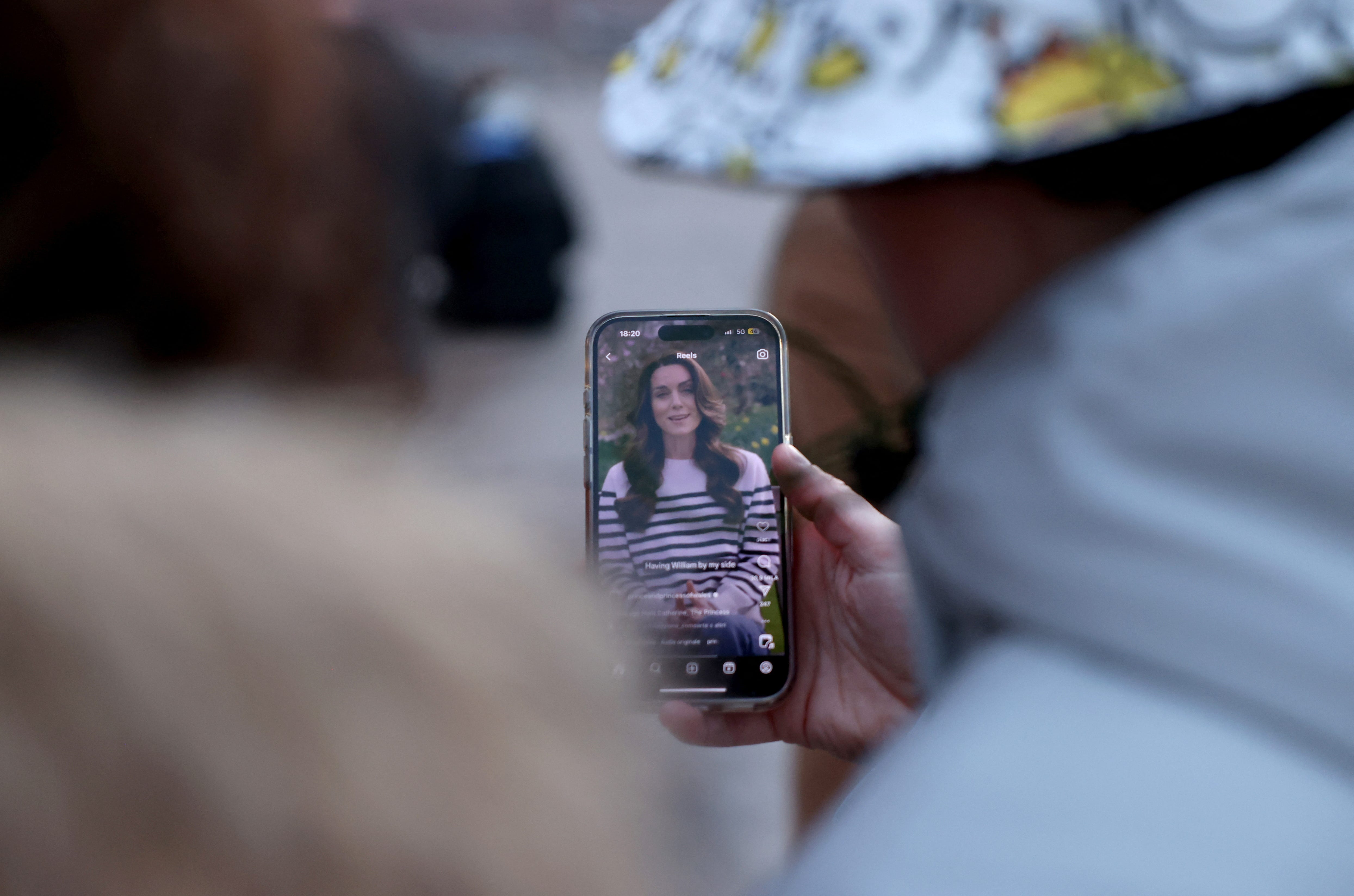 People watch Britain's Catherine, Princess of Wales' announcement about her health, outside Buckingham Palace in London, Britain, March 22, 2024.