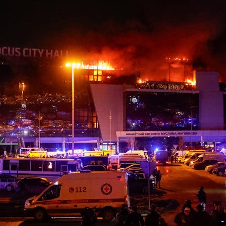 Ambulances and vehicles of Russian emergency services are parked at the burning Crocus City Hall concert venue following a shooting incident, outside Moscow, Russia, March 22, 2024.