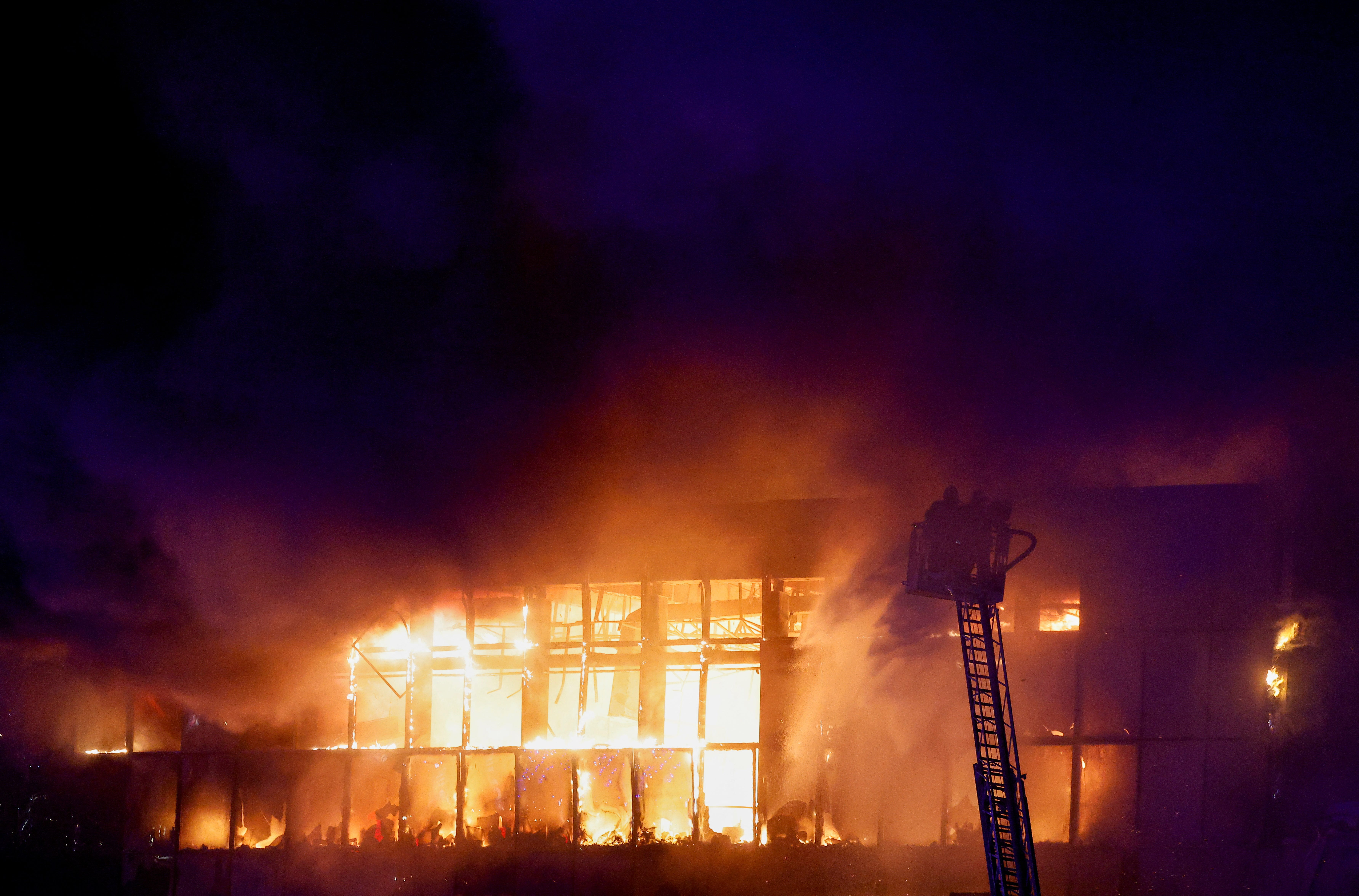 Rescuers work to extinguish fire at the burning Crocus City Hall concert venue following a shooting incident, outside Moscow, Russia, March 22, 2024.