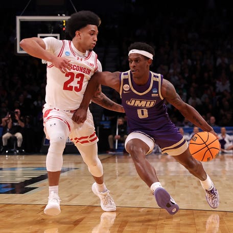 James Madison Dukes guard Xavier Brown (0) dribbles the ball against Wisconsin Badgers guard Chucky Hepburn (23) in the first round of the 2024 NCAA Tournament.