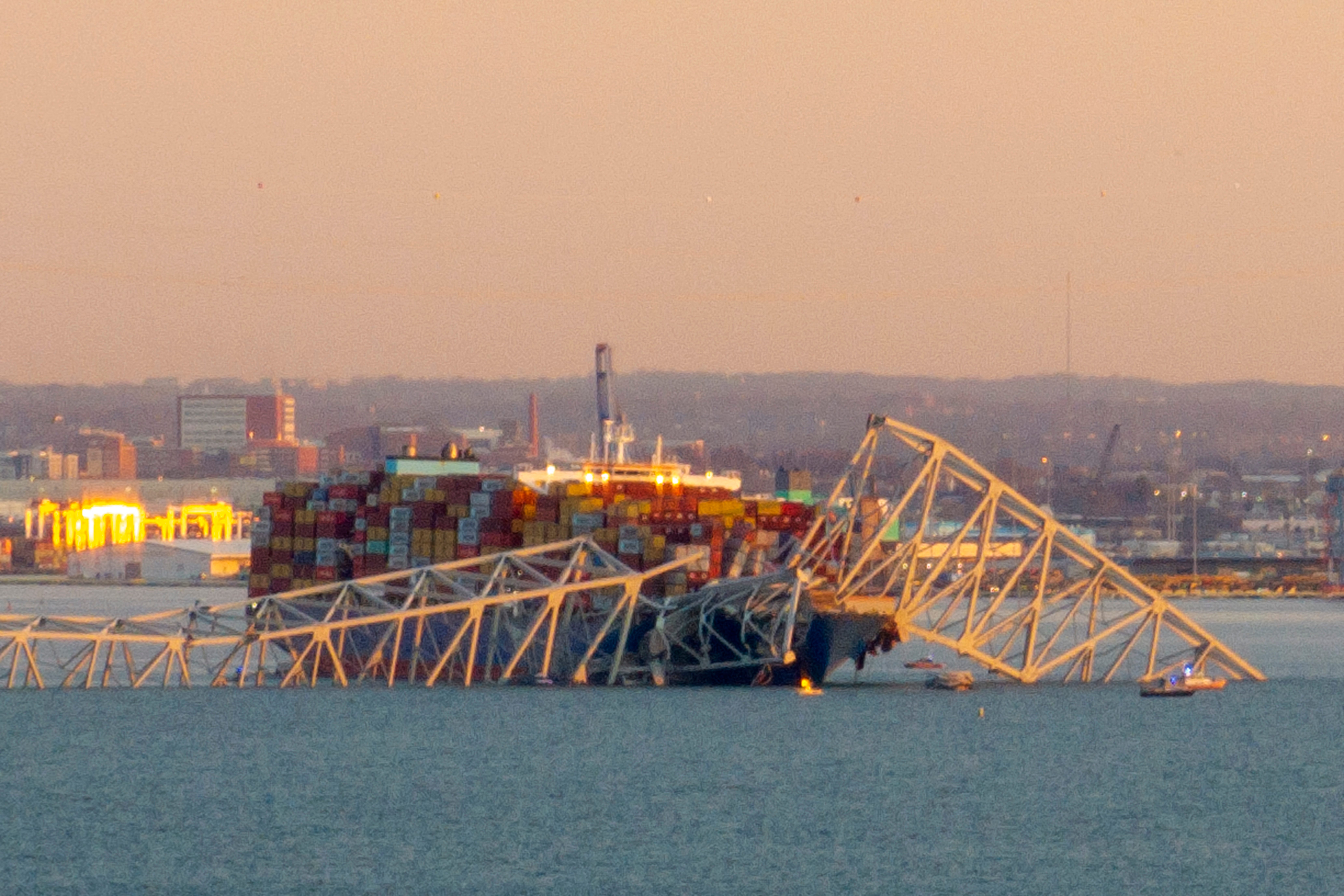 The steel frame of the Francis Scott Key Bridge sits on top of a container ship after it struck the bridge in Baltimore, Maryland, on March 26, 2024. The collapse sent multiple vehicles and up to 20 people plunging into the harbor below. "Unfortunately, we understand that there were up to 20 individuals who may be in the Patapsco River right now as well as multiple vehicles," Kevin Cartwright of the Baltimore Fire Department told CNN. Ship monitoring   website MarineTraffic showed a Singapore-flagged container ship called the Dali stopped under the bridge.