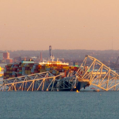 The steel frame of the Francis Scott Key Bridge sits on top of a container ship after it struck the bridge in Baltimore, Maryland, on March 26, 2024. The collapse sent multiple vehicles and up to 20 people plunging into the harbor below. "Unfortunately, we understand that there were up to 20 individuals who may be in the Patapsco River right now as well as multiple vehicles," Kevin Cartwright of the Baltimore Fire Department told CNN. Ship monitoring   website MarineTraffic showed a Singapore-flagged container ship called the Dali stopped under the bridge.