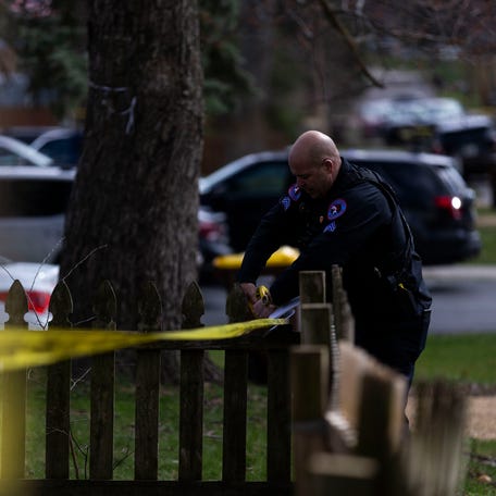 A police officer rolls out crime scene tape on Wednesday, March 27, 2024, near Cleveland Avenue in Rockford.