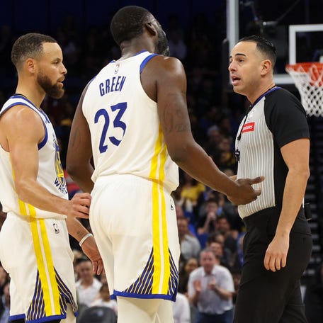 Draymond Green (23) talks to referee Ray Acosta (54) after receiving a foul in the first quarter against the Orlando Magic at the Kia Center.