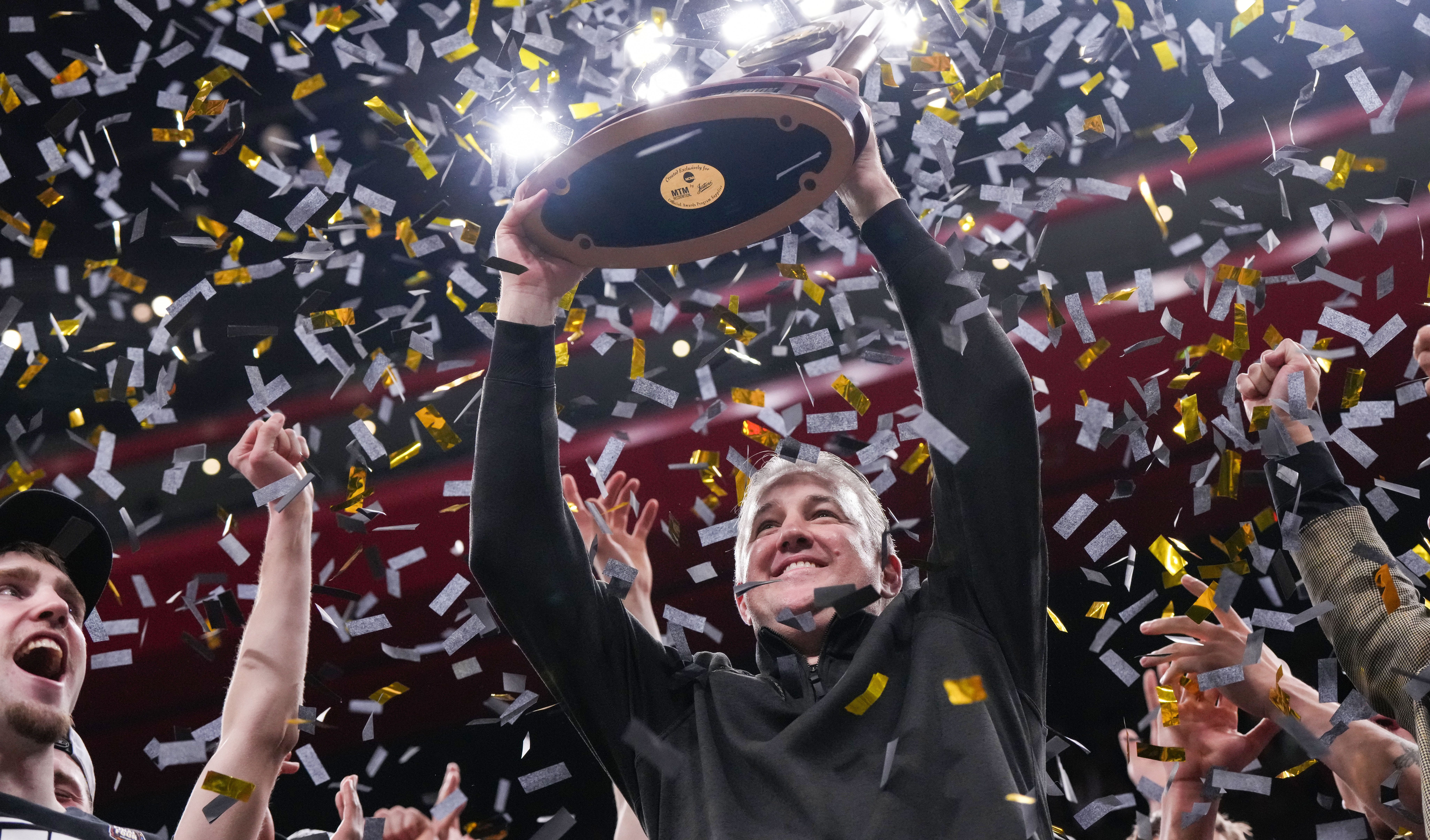 Purdue Boilermakers head coach Matt Painter holds up the NCAA midwest regionals trophy Sunday, March 31, 2024, after the midwest regional finals at the Little Caesars Arena in Detroit.