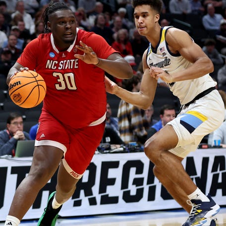 North Carolina State forward DJ Burns Jr. (30) drives against Marquette forward Oso Ighodaro (13) during the South Regional semifinals in the 2024 NCAA men's tournament at American Airlines Center.