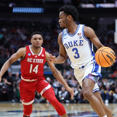 Duke Blue Devils guard Jeremy Roach (3) controls the ball against North Carolina State Wolfpack guard Casey Morsell (14) during their Elite Eight game in the 2024 NCAA men's tournament.