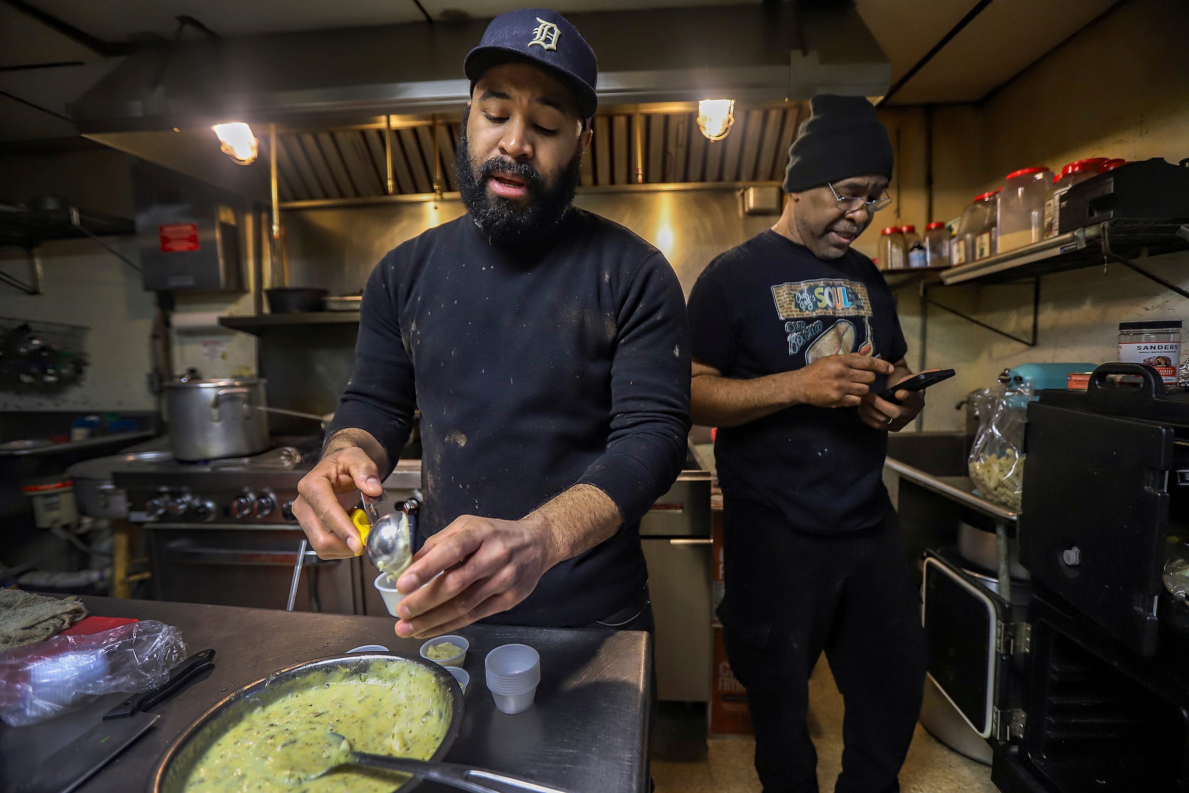 Greg Beard Jr., 36, of Detroit, works with his father, Chef Greg Beard, 62, of Detroit, in the kitchen prepping tartar sauce and helping make his famous, 14-ingredient Boogaloo sauce at Chef Greg's Soul "N" the Wall restaurant in northwest Detroit, on Wednesday, April 3, 2024.