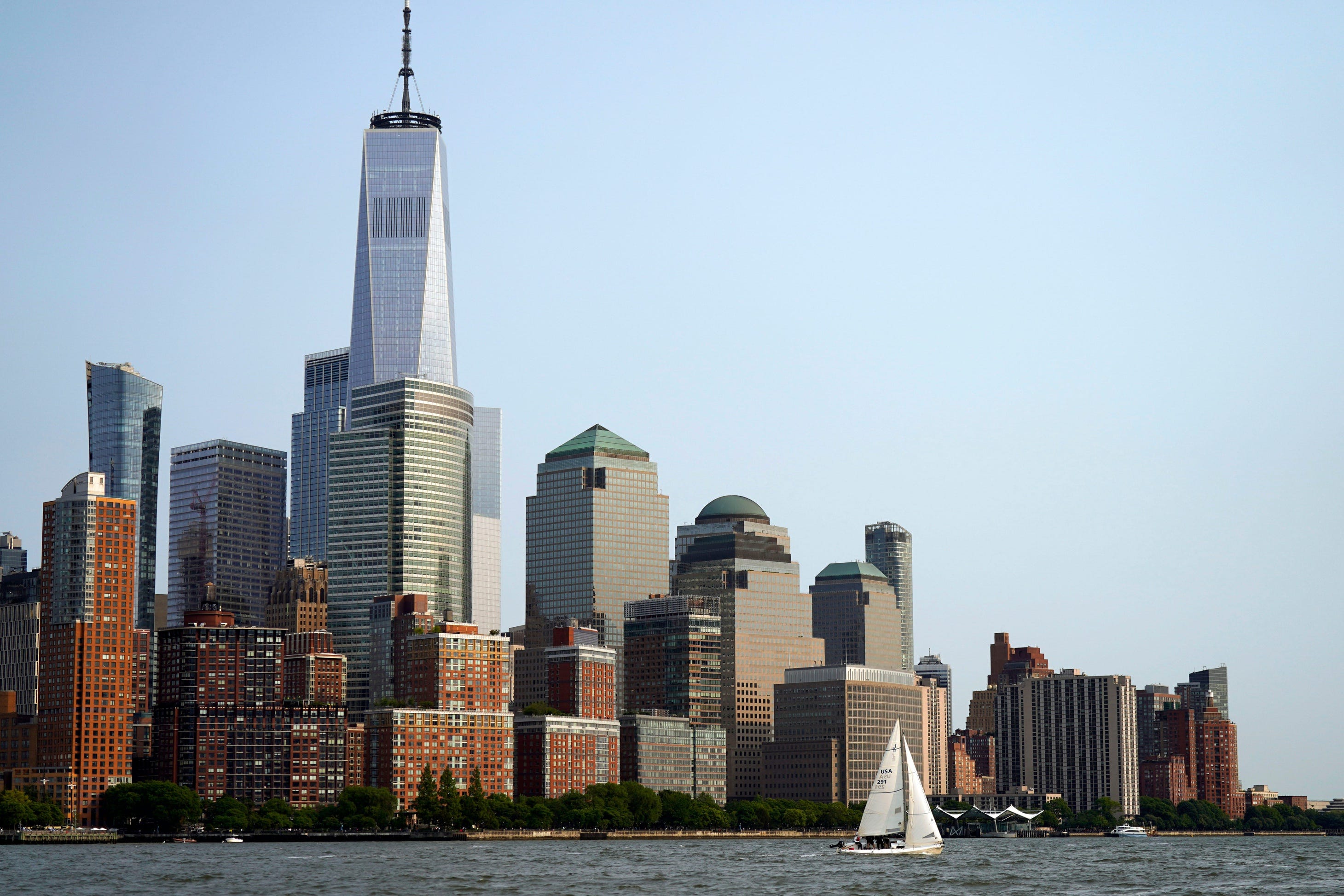 One of the racers with the Hoboken Sailing Club sails past lower Manhattan before their race in the New York Harbor on Wednesday, May 24, 2023. The Hoboken Sailing Club hosts youth sailing camps, individual and group lessons, and members can participate in races in the New York harbor.