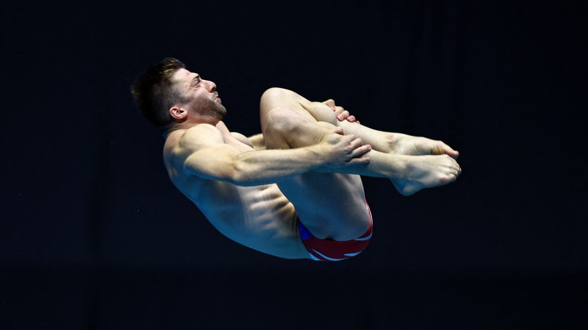 Frenchman Alexis Jandar slides down a diving board at the Olympics opening ceremony