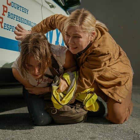 Lee (Kirsten Dunst, right) saves Jessie (Cailee Spaeny) during a suicide bombing in "Civil War."