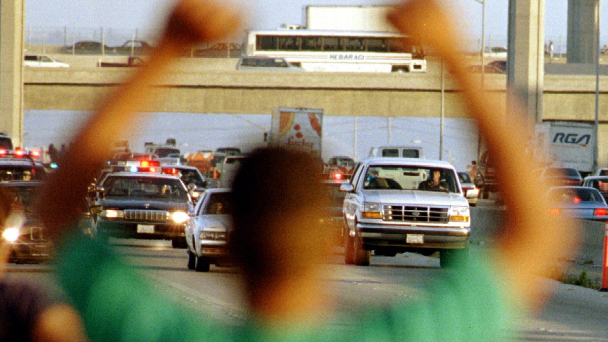 A Man Cheers As The Ford Bronco Carrying Oj Simpson R Is Chased By Dozens Of Police Cars During A