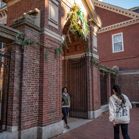 People enter and exit Harvard Yard at a gate at Harvard University in Cambridge, Massachusetts on December 12, 2023.
